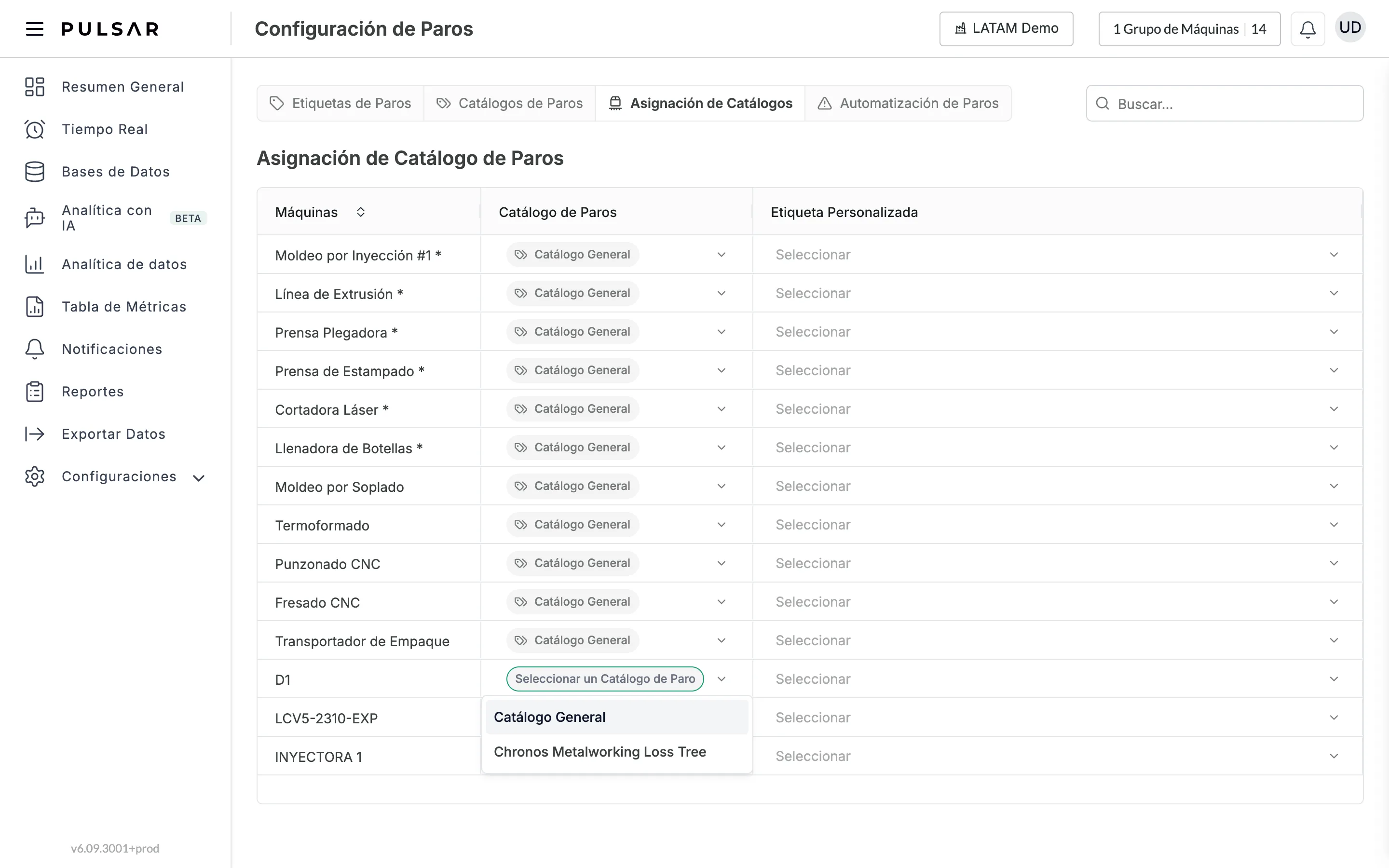 Configuración de Paros, pestaña Asignación de Catálogos: la tabla Asignación de Catálogo de Paros con las columnas Máquinas, Catálogo de Paros y Etiqueta Personalizada. La mayoría de las máquinas muestran Catálogo General, y el menú Catálogo de Paros de una máquina que dice Seleccionar un Catálogo de Paro está abierto con los catálogos disponibles.